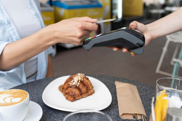 Plată cu cardul pentru croissant și cafea